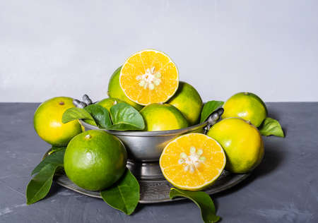 Mapo fruits in the tin bawl and plate on gray backgroundの写真素材