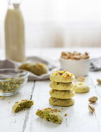 pistachios cookies and ingredients on the white wooden backgroundの写真素材