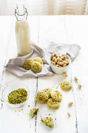 pistachios cookies and ingredients on the white wooden backgroundの写真素材