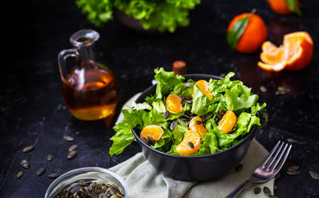 Lettuce salad with tangerines, olive oil, pumpkin seedsの写真素材