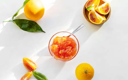Red oranges jam in glass bowl with fruitsの写真素材