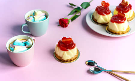 Bavarian cream pastry with strawberry jelly, two cups and rose