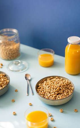Breakfast concept with cold cereals and orange juice on blue backgroundの写真素材