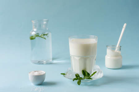 Ayran or Doogh is a popular refreshing Middle Eastern beverage made with yogurt, water and salt. Blue backgroundの写真素材