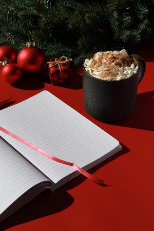 red Christmas composition with hot chocolate and note book for wish listの写真素材