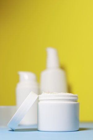mock up of white jar of cream on a yellow background. Ready place for the label, copy spaceの写真素材