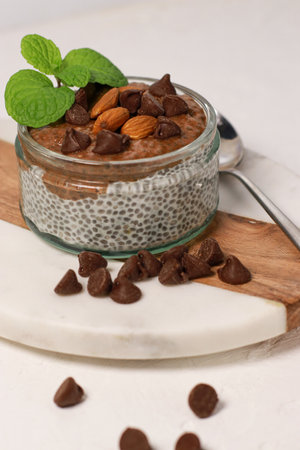 chia pudding with chocolate and almonds on white tableの写真素材