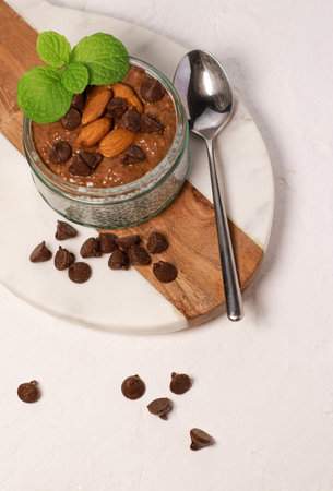 chia pudding with chocolate and almonds on white tableの写真素材
