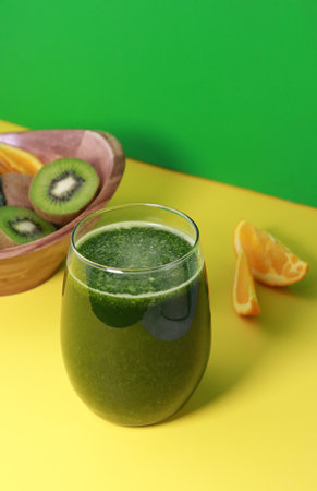 delicious fresh green kiwi smoothie with orange juice on yellow background, copy spaceの写真素材