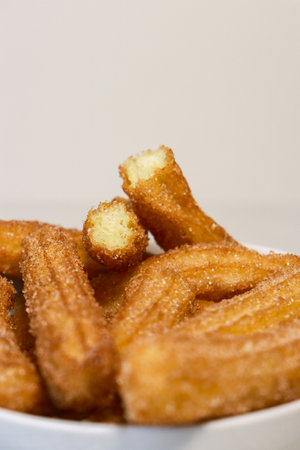 close up of churros with sugar in white bowl, top viewの写真素材