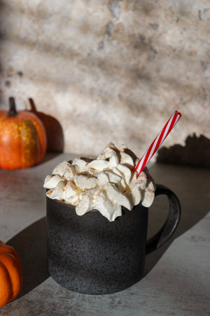 pumpkin cinnamon spice latte on grey marble table, pumpkins in backgroundの写真素材