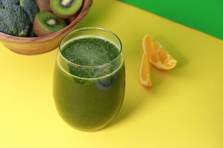 delicious fresh green kiwi smoothie with orange juice on yellow background, copy spaceの写真素材