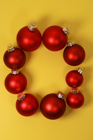 red Christmas ornament balls on yellow background. Flat lay, top view, copy spaceの写真素材