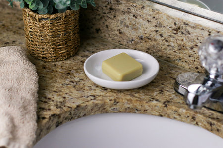 a bar of zero waste soap on white dish at bathroom sinkの写真素材