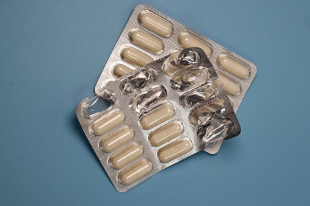 close up of white pills capsules on blue background, top viewの写真素材