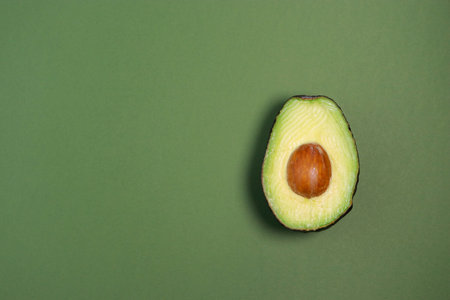 close up of fresh ripe avocado on green background, copy spaceの写真素材
