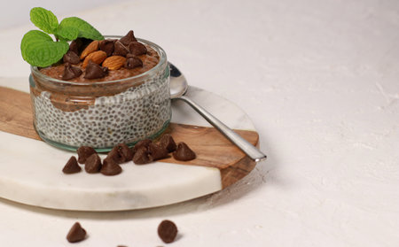 chia pudding with chocolate and almonds on white tableの写真素材