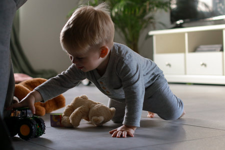 little boy playing with toy car in living room, blurred backgroundの写真素材