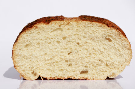 close up of a cut of white bread loaf on shite background