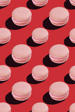 seamless pattern of pink macaroon cookies on red backgroundの写真素材