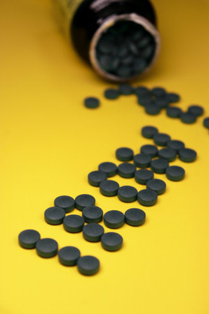 close up of green iron vitamin pills on yellow backgroundの写真素材