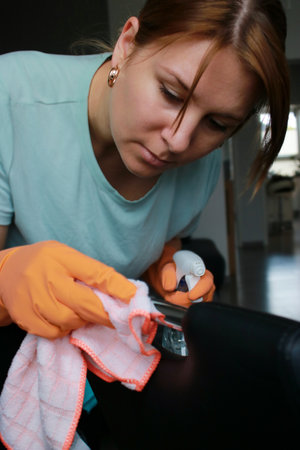 caucasian woman cleaning in orange rubber gloves at homeの写真素材