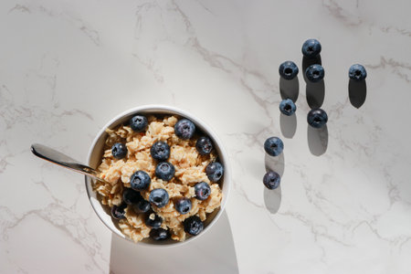 top view of healthy vegan oatmeal with blueberries in white porcelain bowlの写真素材