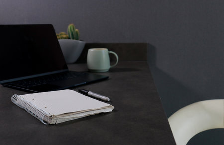 Close up of blank notebook with laptop computer and green cup of coffeeの写真素材