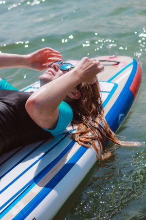 A beautiful young woman sunbathing on a sub in the sea. Summer vacations in the sun.