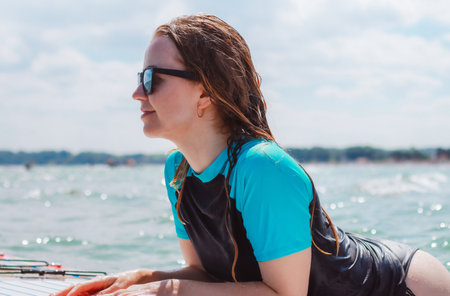 A beautiful young woman laughing and having fun on a sup in the sea.の写真素材