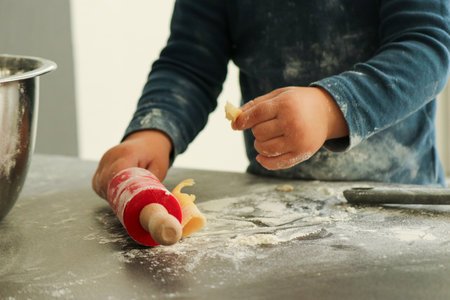 Close up of little boys hands making Christmas cookies at home