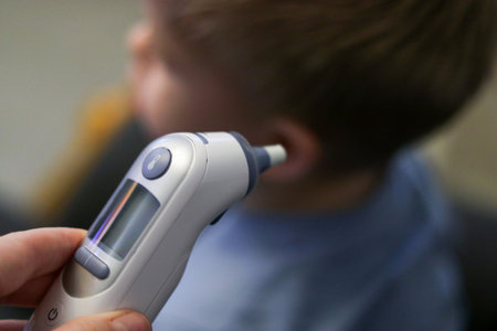 Close-up thermometer. Mother measuring temperature of her ill kid. Sick child with high fever in bed