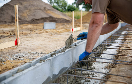 Close up of a bricklayer worker making cement mortar on a wall block
