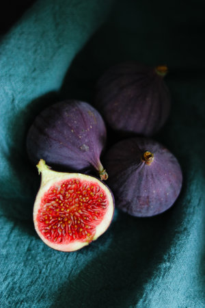 Close up of fresh ripe fig fruits in green fabric with dark shadowsの写真素材