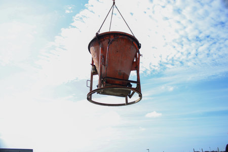 A crane with concrete bucket on construction site, filling floor ground with concreteの写真素材