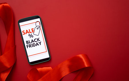 Top view of a smartphone screen displaying a Black Friday online sale on red backgroundの写真素材