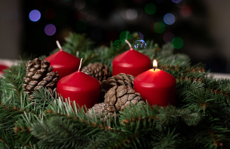 Close up of an advent wreath with one red burning candle on white table in the living room, blurry light backgroundの写真素材