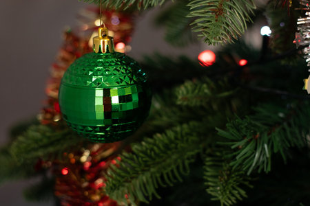 Close up of a green ornament ball decoration hanging on a Christmas treeの写真素材