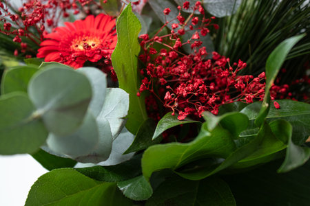 Close up of a bouquet with red flowers and green different leavesの写真素材