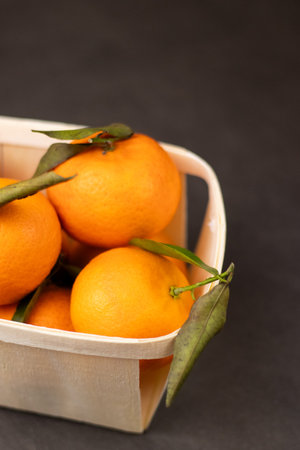Close up of mandarine fruits in a wooden box on grey table backgroundの写真素材
