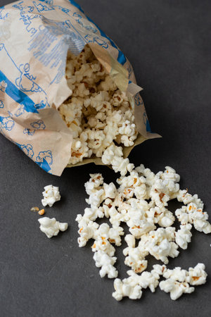 Fresh popcorn in bag made in a microwave on grey kitchen tableの写真素材