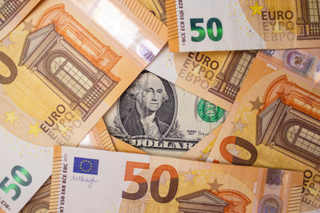 Close up of fifty euro money bills and a dollar bill in the middle background