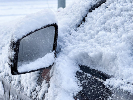 Close up of a car side mirror covered with snow in winterの写真素材