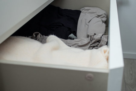Close up of warm knitted cloths folded in a white dresserの写真素材