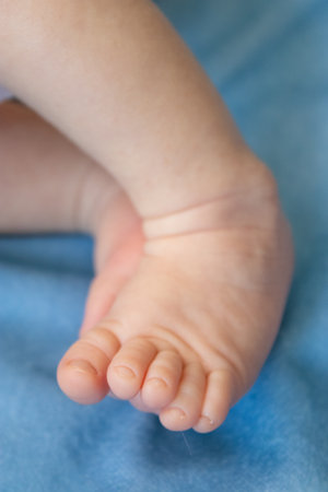 Close up of a newborn babys tiny feet, sleeping in a cozy bedの写真素材