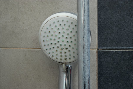 Close up of a shower head with limescale stains in the showerの写真素材