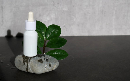 A white bottle of facial serum on grey stone with grey minimalistic background.の写真素材