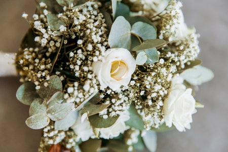 Golden wedding on the beautiful bouquet of a bride on grey table