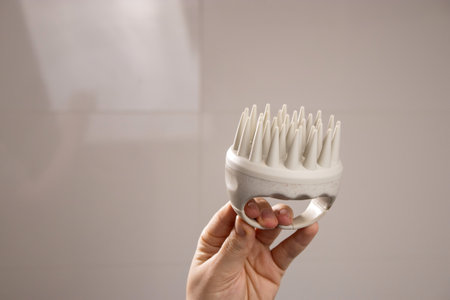 Close up of a beige scalp massager for hair growth stimulation