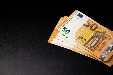 Close up of fifty euro money bills on black backgroundの写真素材